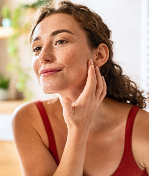 A photo of a woman applying face cream.