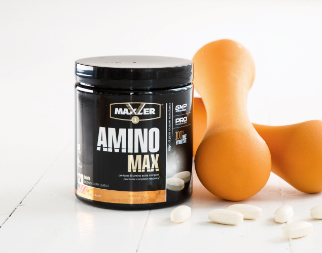 A photo of Amino MAX container with a few capsules near it.