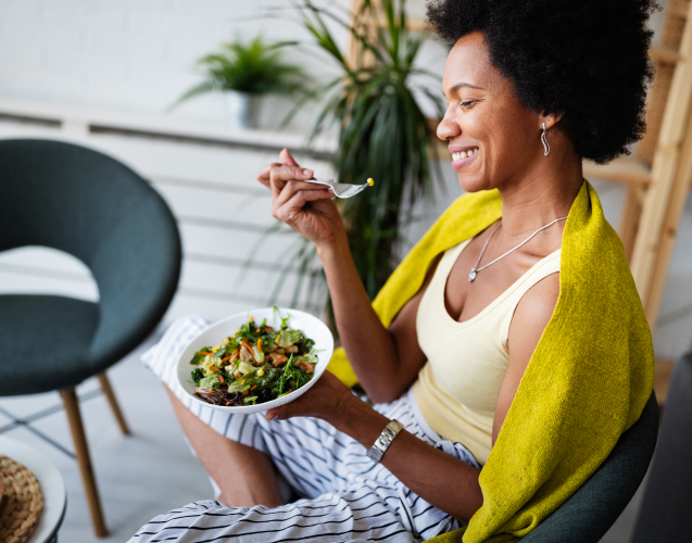 A woman eating a green salad