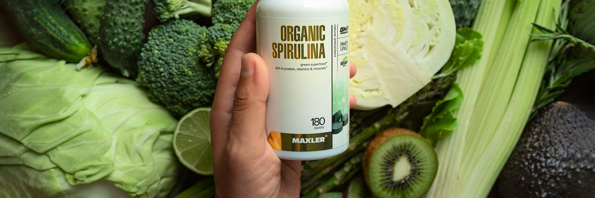 A photo of a hand holding a bottle of Organic Spirulina.