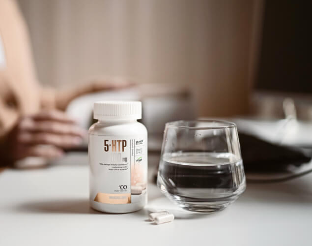 A bottle of 5-HTP and a glass of water